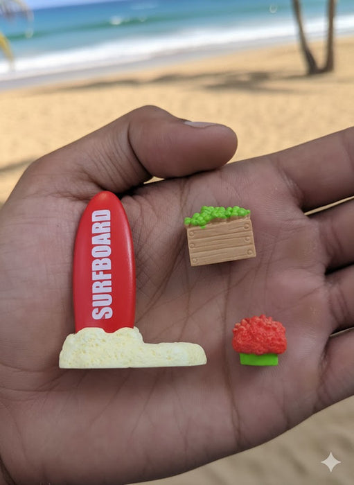 beach holding miniature toys: a surfboard, a planter box, and a flower.