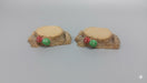 Two miniature resin tree stumps with tiny red and green mushrooms on a gray background.