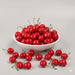 Set of 20 realistic artificial red cherries with green stems shown overflowing from a clear glass bowl onto a white surface. Ideal for photo props and home kitchen decor.