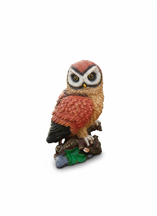Decorative resin statue of a orange  horned owl on a base of wood and stone."