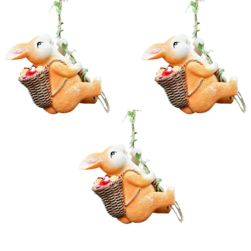 Three hanging resin bunny statues climbing a rope with fruit baskets, whimsical garden tree ornaments, hand-painted orange rabbit figurines for outdoor decor on a white background.