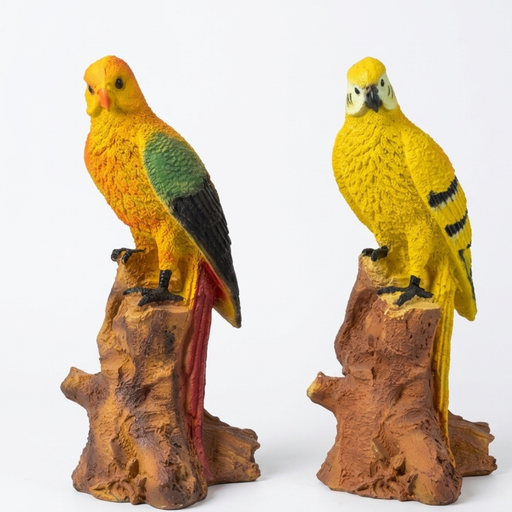 Two colorful tropical bird statues, a Sun Conure and a yellow parrot, perched on faux-wood stumps in a garden setting with terracotta pots and white jasmine flowers.