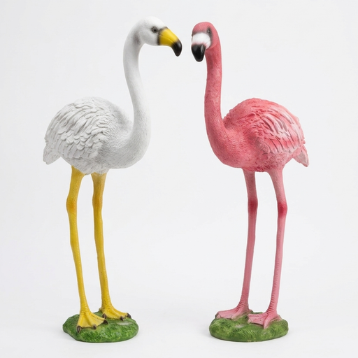 Set of two realistic flamingo garden statues in pink and white withcurved necks standing on a grass lawn.