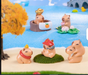 A colorful product photography display featuring a set of cute capybara miniature figurines in various relaxing poses, including one in a hot spring tub with a gold ingot, another on lily pads, one wearing a fast-food visor, and others cuddling on a sandy beach-themed setup.