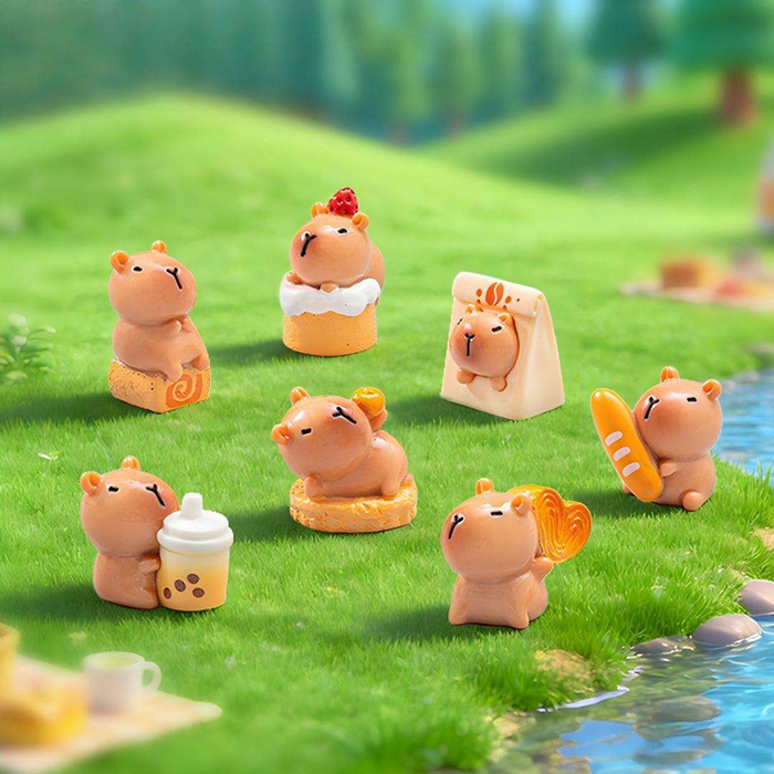 Set of 7 cute capybara miniature figurines interacting with food and drinks on a green