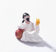 miniature wise sage figurine wearing white traditional robes with a black hair topknot and beard, sitting next to a brown pouch and holding a yellow