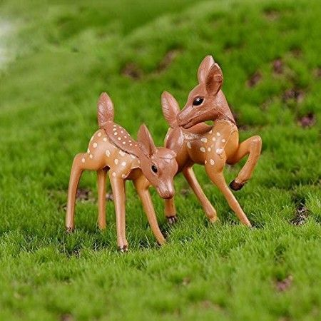 Set of two miniature spotted baby deer figurines standing on green artificial moss for fairy garden and terrarium decor