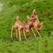 Set of two miniature spotted baby deer figurines standing on green artificial moss for fairy garden and terrarium decor