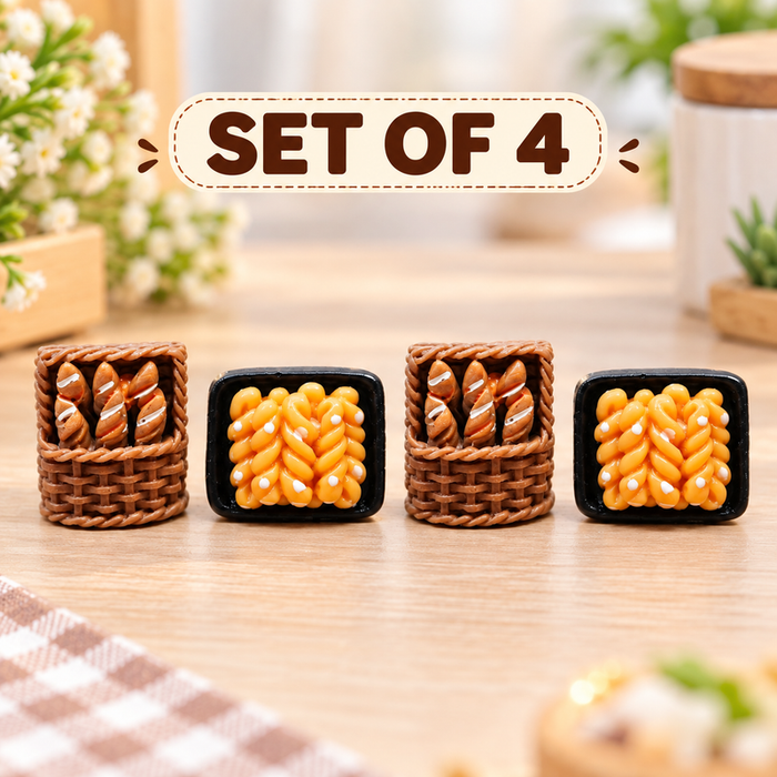 Handcrafted miniature set of four pieces including a small brown woven basket filled with tiny baguettes and a black tray of glazed twisted pastries