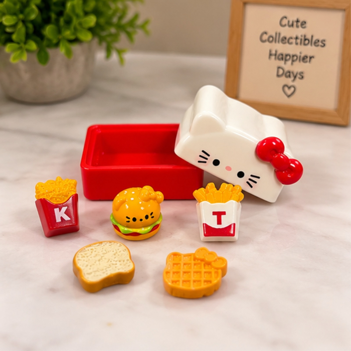 A cute white Hello Kitty-shaped storage box with a red base, displayed alongside six miniature fast-food collectibles including a burger, fries, toast, and a waffle