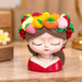 4-inch resin face planter shaped like a cute girl with a colorful fruit crown and red dress, sitting on a table top