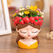4-inch resin girl face planter wearing a red strawberry crown and yellow top, displayed on a wooden surface.