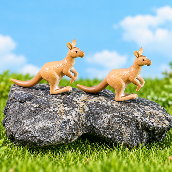 A miniature kangaroo figurine standing on a dark grey rock surrounded by artificial green grass