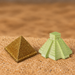 Miniature light green Mayan stepped temple pyramid resting on sand background.