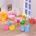 15-piece set of kawaii animal-themed miniature dollhouse furniture including mini bed, fridge, elephant wardrobe, chairs, and bear fireplace.